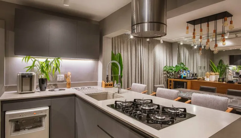 A cozinha em península facilita a organização, pois permite trabalhar com móveis na extensão da bancada, como é o caso do projeto de Renan Altera. Foto: Photons Fotografia/Renan Altera