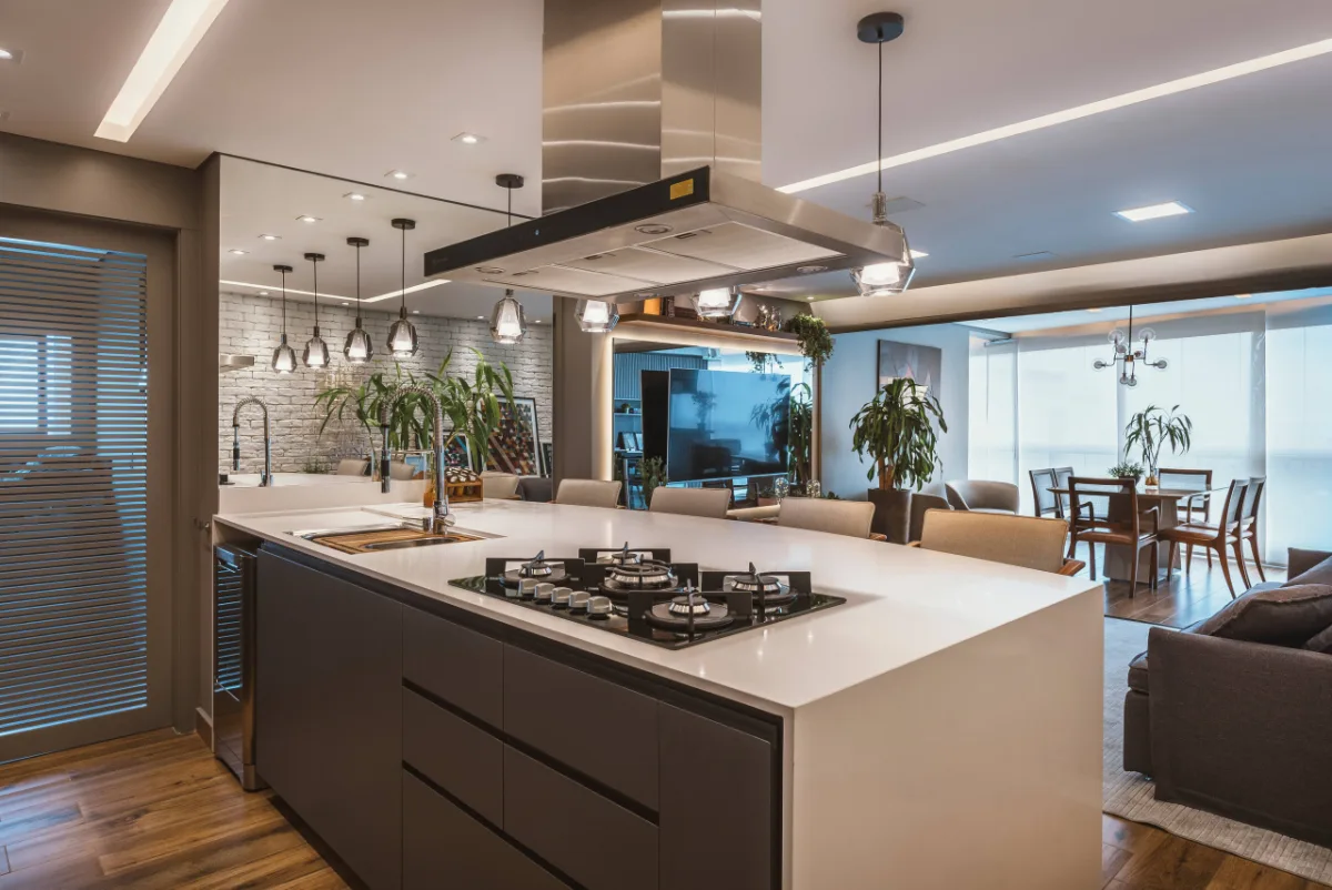 A bancada da península realizada pelo arquiteto Renan Altera conta com cooktop a gás, cuba com torneira gourmet e exaustor. Foto: Photons Fotografia/Renan Altera