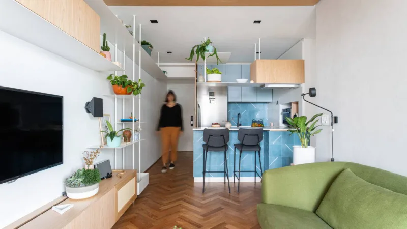 No projeto do Estúdio Bra, estante avança da sala até o hall e a cozinha do apartamento Góes. Foto: Divulgação