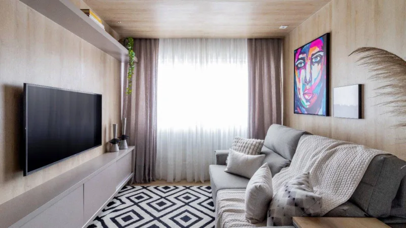 Sala foi revestida com painéis em madeira e piso vinílico que colocaram o cômodo dentro de uma "caixa". Foto: Divulgação/Flávia Franco