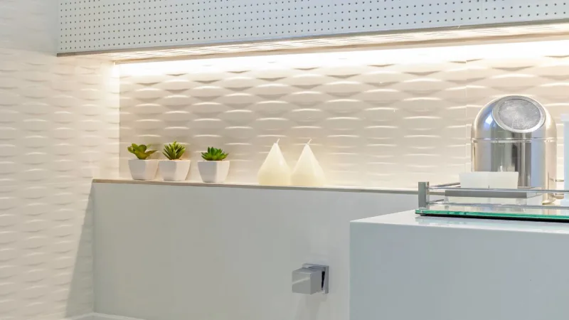 Diferentes texturas e iluminação amarela para quebrar a rigidez do branco.