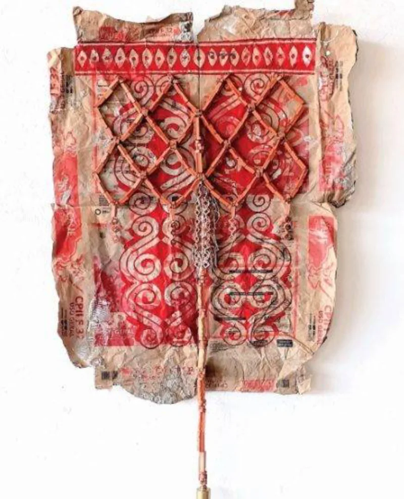 Arte "Sobre a Pele", de Andrey Zignnatto, na Galeria Janaína Torres: urucum
com resina acrílica, cerâmica e barbante sobre papel de saco.