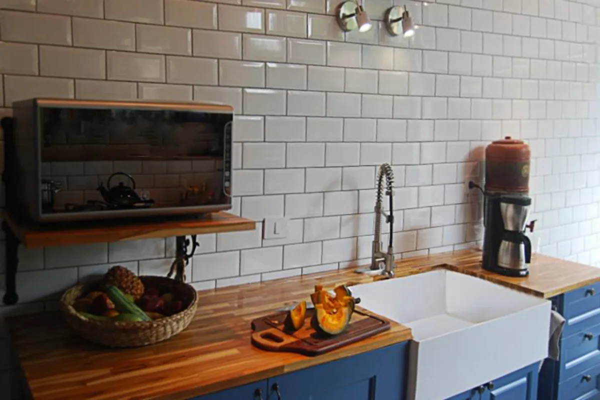 Cozinha foi reformada em tons de azul, móveis provençal, azulejos retrô e piso geométrico.