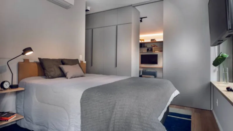 Armário e porta de correr dividem quarto e sala em estúdio. Foto: Escanhuela Fotografias
