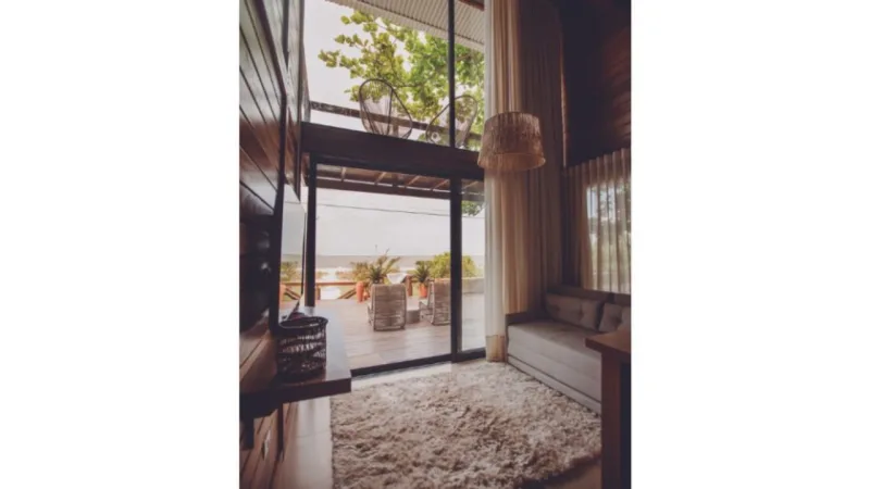 Interior da suíte duplex de 40 m², com janelas de fora a fora que aproveitam ao máximo a luz natural e a vista diferenciada, de frente para o mar.