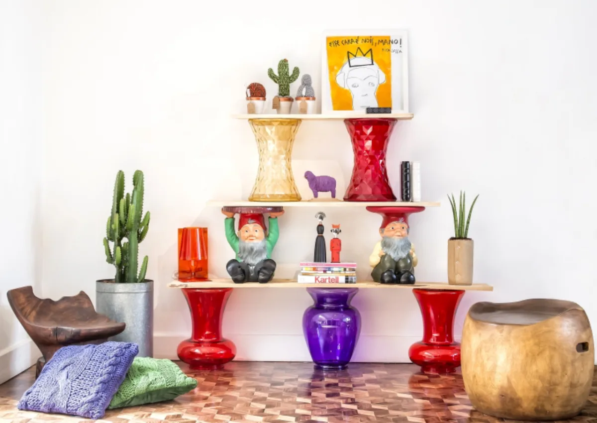 Estante de madeira crua com banquinhos da Kartell encontrados na Kraft Home Store. A ideia é da designer de interiores Renata McCartney. Destaque para os bancos de anões Attila e Napoleon, criações de Philippe Starck, e para os cactos mexicanos de tricô na parte superior, de autoria da designer. Foto: Letícia Akemi/Gazeta do Povo 