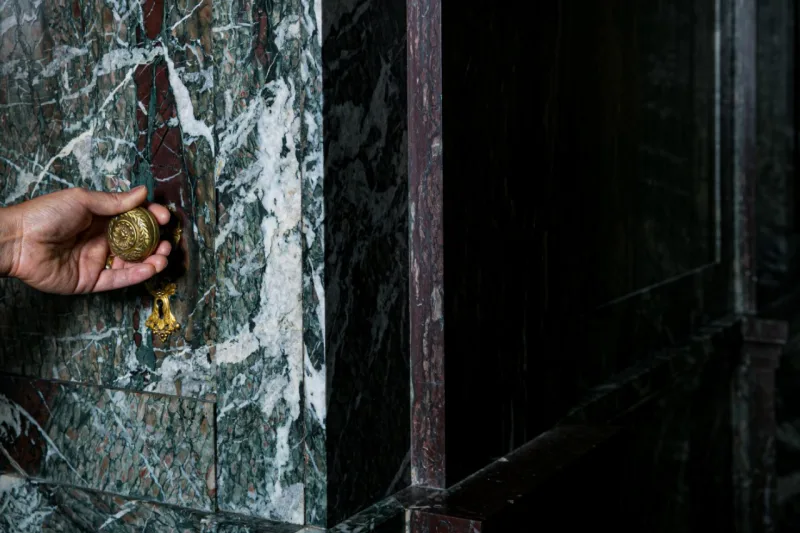 The doorknob for a hidden door in a conference room in marbled offices that once belonged to F.W. Woolworth, which architect Kang Chang restored for his firm Kang Modern, in New York, Aug. 9, 2019. Secret rooms are popping up in workplaces. (Jeenah Moon/The New York Times)