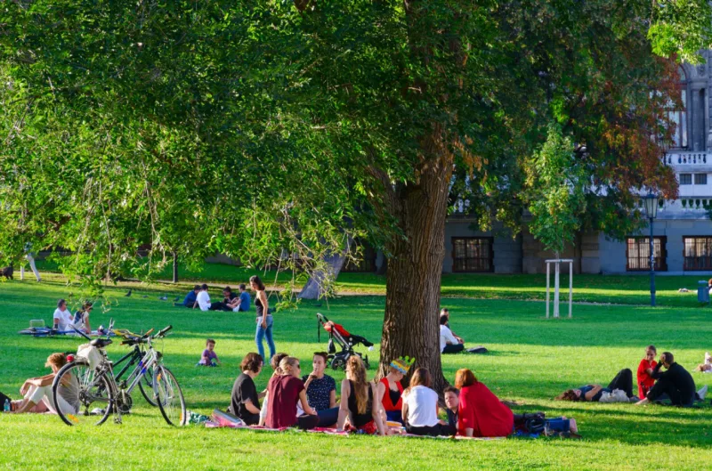 VIENNA, AUSTRIA - SEPTEMBER 17, 2018: Company of young people is resting in popular public Burggarten park on sunny September day, Vienna, Austria