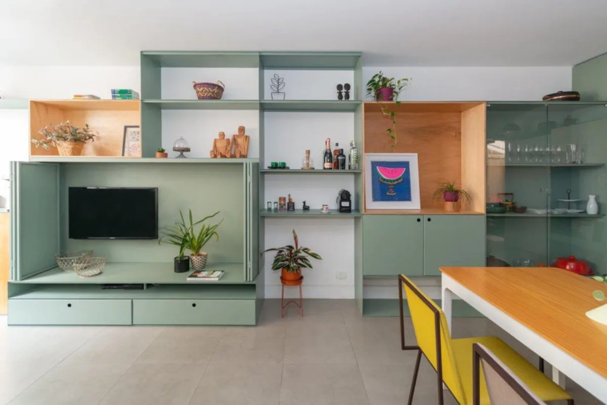 Um móvel multifuncional ocupa boa extensão da sala e serve para vários usos. Foto: Cris Farhat / Divulgação 