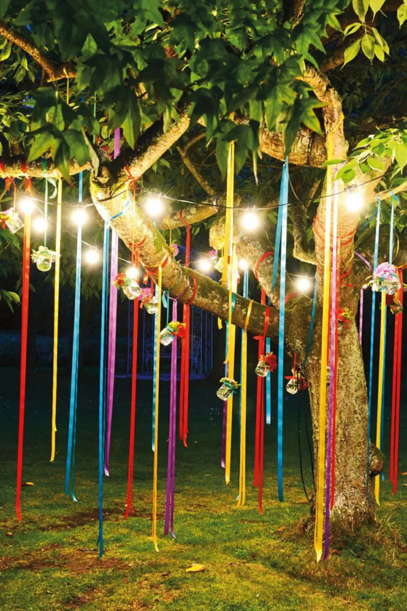 Não interessa o tamanho do seu jardim. Inclua seu espaço externo na folia das comemorações juninas. Uma boa dica é fazer uso das árvores do quintal. Pendure fitas de diferentes cores, potes com flores e até pisca-piscas (é só tirar do armário as luzinhas de Natal!).
Foto: Reprodução Pinterest