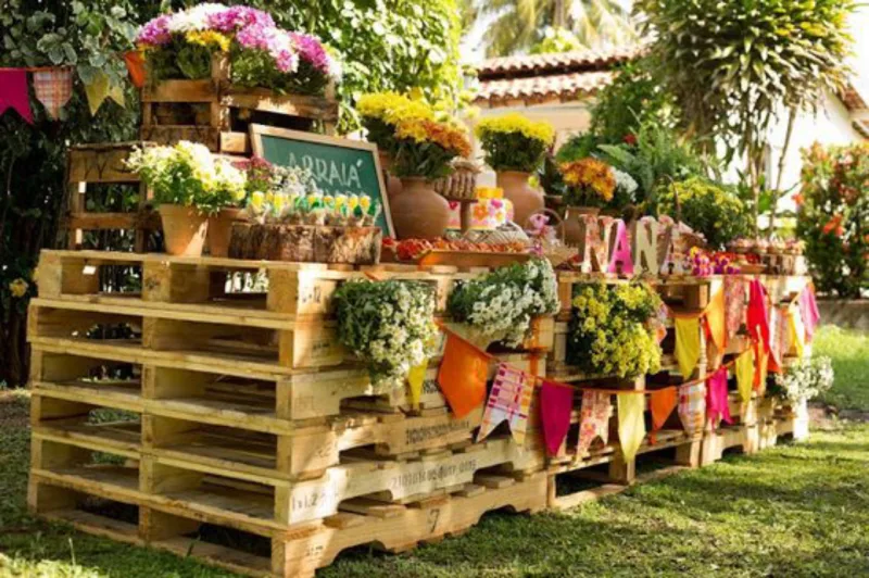 Na dúvida, use palets para montar sua mesa para a festa junina. É empilhar algumas até a altura de sua preferência e decorar as estruturas com bandeirinhas e flores. Mais fácil, impossível!
Foto: Reprodução / Pinterest