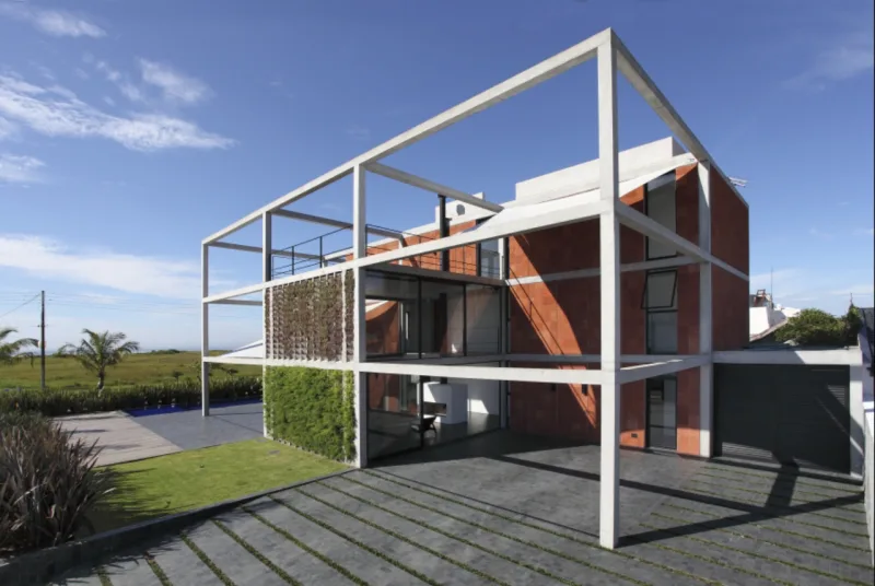 Estrutura em concreto é preenchida com massas construídas e revestidas com arenito vermelho no projeto de Marcos Bertoldi no balneário de Atami, em Pontal do Paraná. A concepção dos espaços foi feita para aproveitar ao máximo a paisagem. Fotos: Alessandra Okasaki/Divulgação