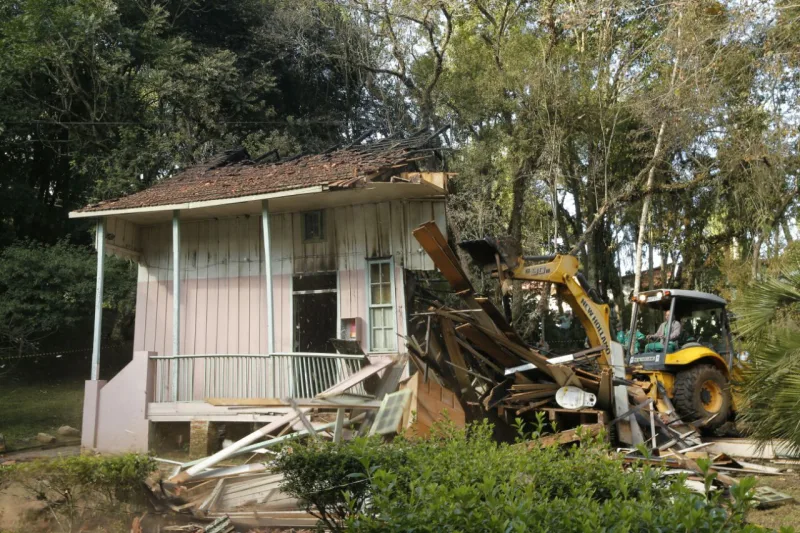 Trator da Prefeitura derruba o que restou da Casa Erbo Stenzel depois do incêndio que queimou boa parte da estrutura, no último dia 14 de junho. Foto: Hugo Harada/Gazeta do Povo