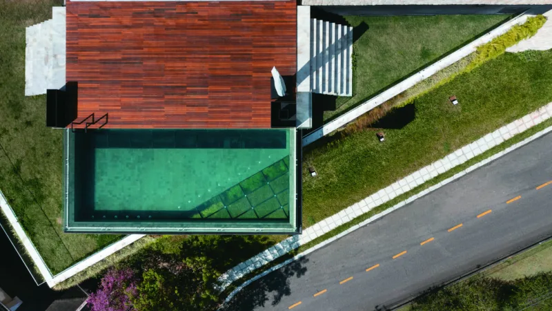 Com fundo de vidro, piscina amplia interação com entorno.