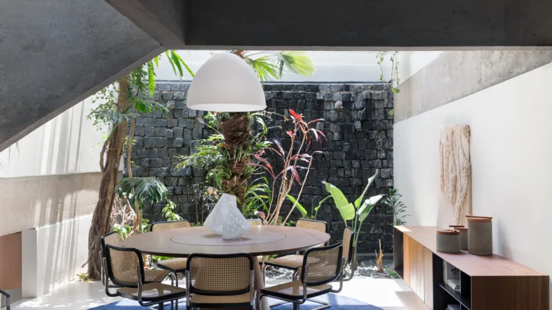 No jantar íntimo, as arquitetas promoveram a integração total com o jardim de inverno, que teve as pedras restauradas. O processo garantiu luminosidade e uma aproximação com a natureza.