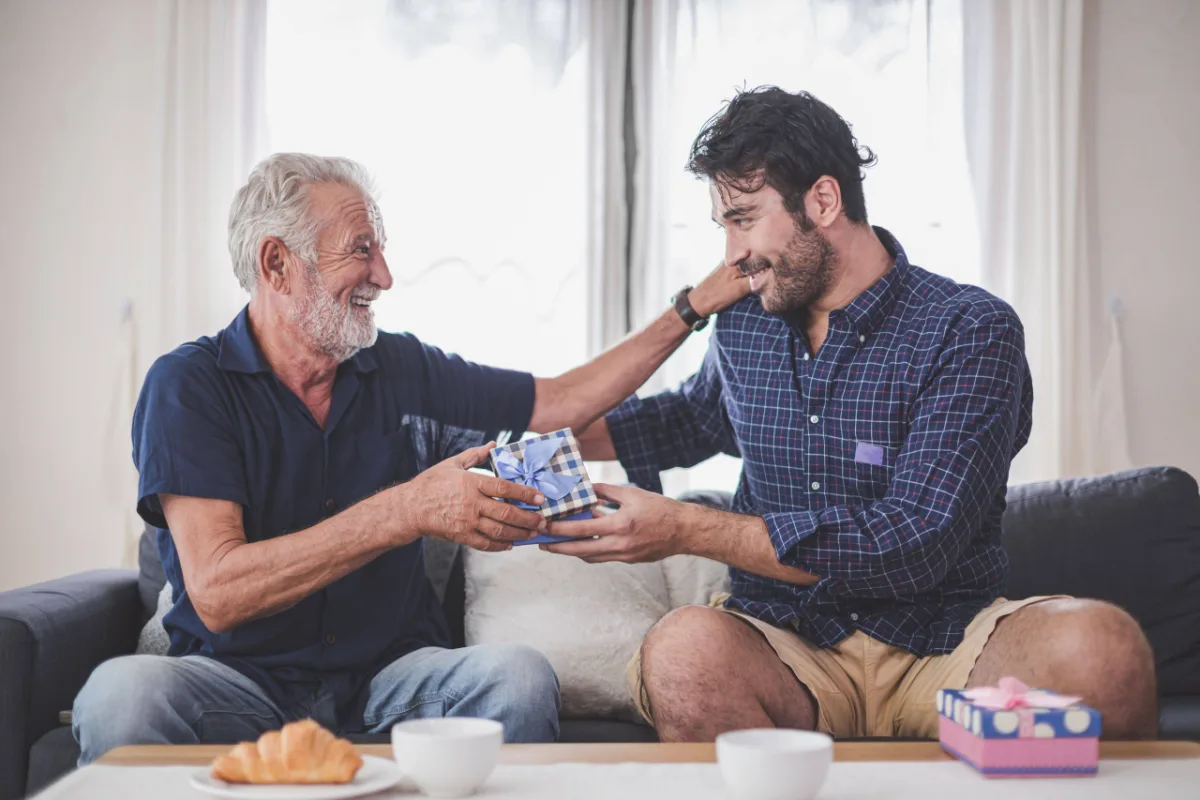 Father’s day concept – Son hold a gift box to give to the father on important occasions. Young man congratulated the old man and gives him a gift. (Father’s day concept – Son hold a gift box to give to the father on important occasions. Young man cong