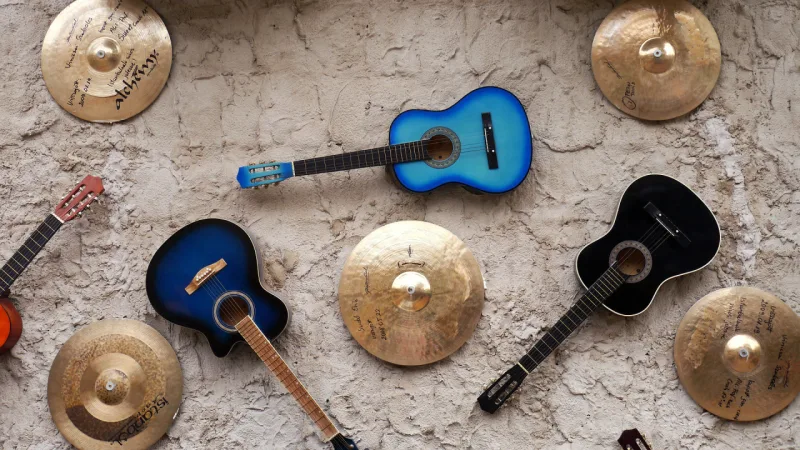 Parede decorada com violões e pratos de bateria autografados. Foto: Pixabay/Reprodução