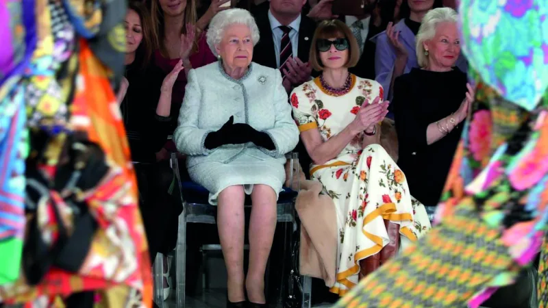 Rainha Elizabeth 2ª sentada em uma Louis Ghost durante desfile de moda de Richard Quinn