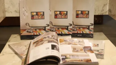 Unidades do Anuário HAUS, três em pé e fechadas atrás, algumas deitadas e fechadas na frente, com uma aberta sobre elas.