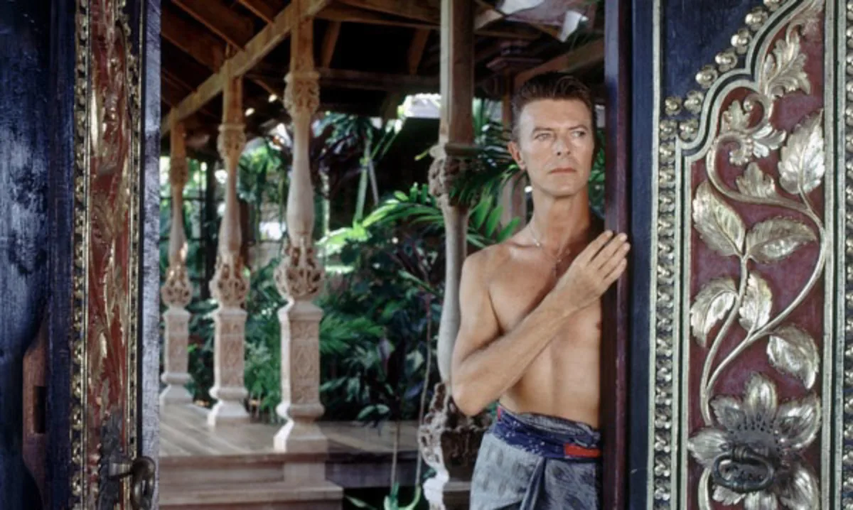 David Bowie posa em sua casa de verão com decoração balinesa, na Ilha de Mustique, no Caribe, durante sessão de fotos para a Architectural Digest, em 1992. Foto: AD/Reprodução/Divulgação
