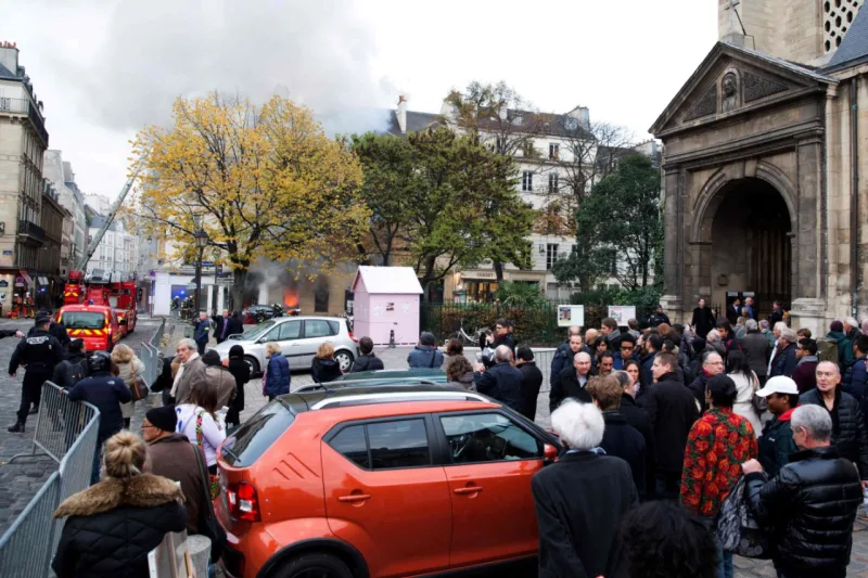 People watch as fire fighters work to put out a fire in "La Hune" book shop in the Saint-Germain-des-Pres district Paris on November 16, 2017.
Seven people were lightly injured in the fire, and some 50 firefighters and a dozen vehicles were deployed. / AFP PHOTO / Karim DAHER