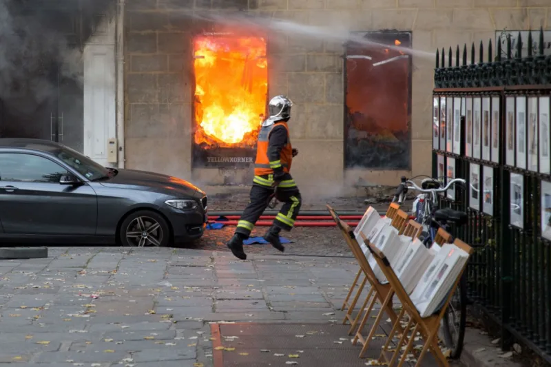 A firefighter runs as he works to put out a fire in "La Hune" book shop in the Saint-Germain-des-Pres district Paris on November 16, 2017.
Seven people were lightly injured in the fire, and some 50 firefighters and a dozen vehicles were deployed. / AFP PHOTO / Karim DAHER