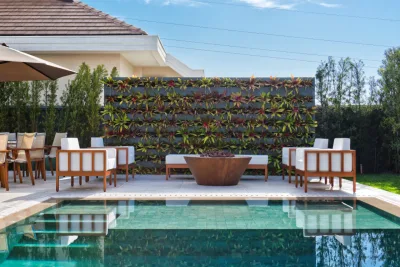 Nessa residência, a piscina está alinhada à parede de bromélias. Foto: Marcelo Stammer