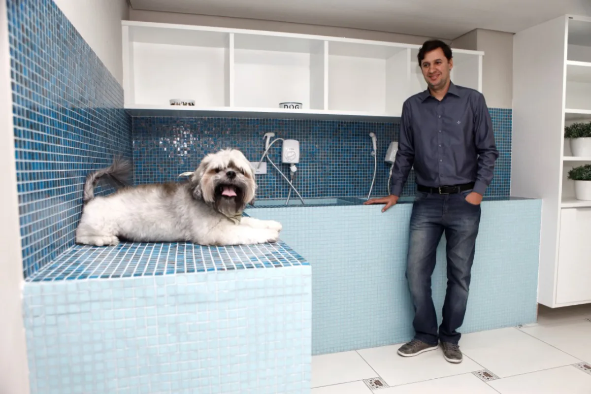 O empresário e síndico Vinicius Ferreira Correia na companhia de Batatinha no espaço pet do condomínio. Foto: André Rodrigues/Gazeta do Povo
