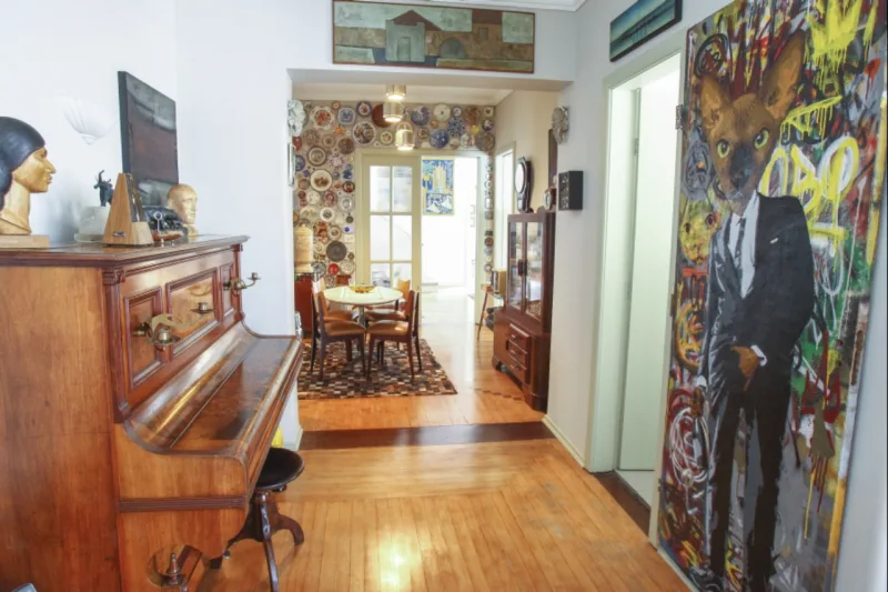 O espaço é uma grande galeria de arte para todos os gostos: tela de Artestenciva e coleção de pratos ao fundo.