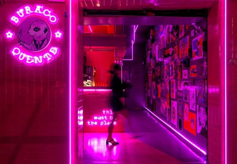 As duas cores do projeto – rosa e roxo – dão unidade às áreas interna e externa do bar, como na aplicação no piso, que guia o cliente