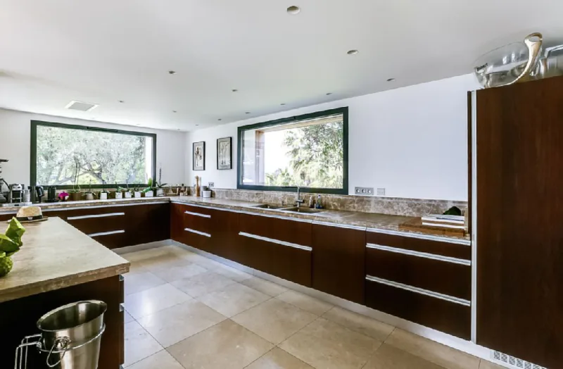 Cozinha da mansão com grandes janelas para integração com a área externa.
Foto: Airbnb / Divulgação