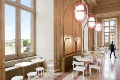 O destaque vai para as luminárias em formato oval e rosadas que ocupam o espaço entre o café o teto (Foto: Divulgação)