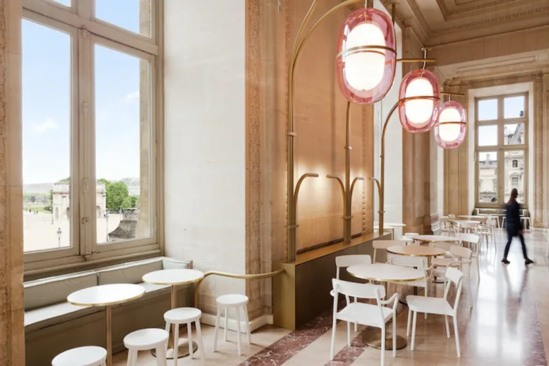 O destaque vai para as luminárias em formato oval e rosadas que ocupam o espaço entre o café o teto (Foto: Divulgação)
