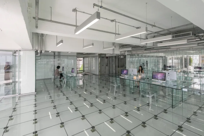O visual do prédio é bem industrial. O vidro está em toda a parte. No piso, nas divisórias, no elevador e até nos móveis.