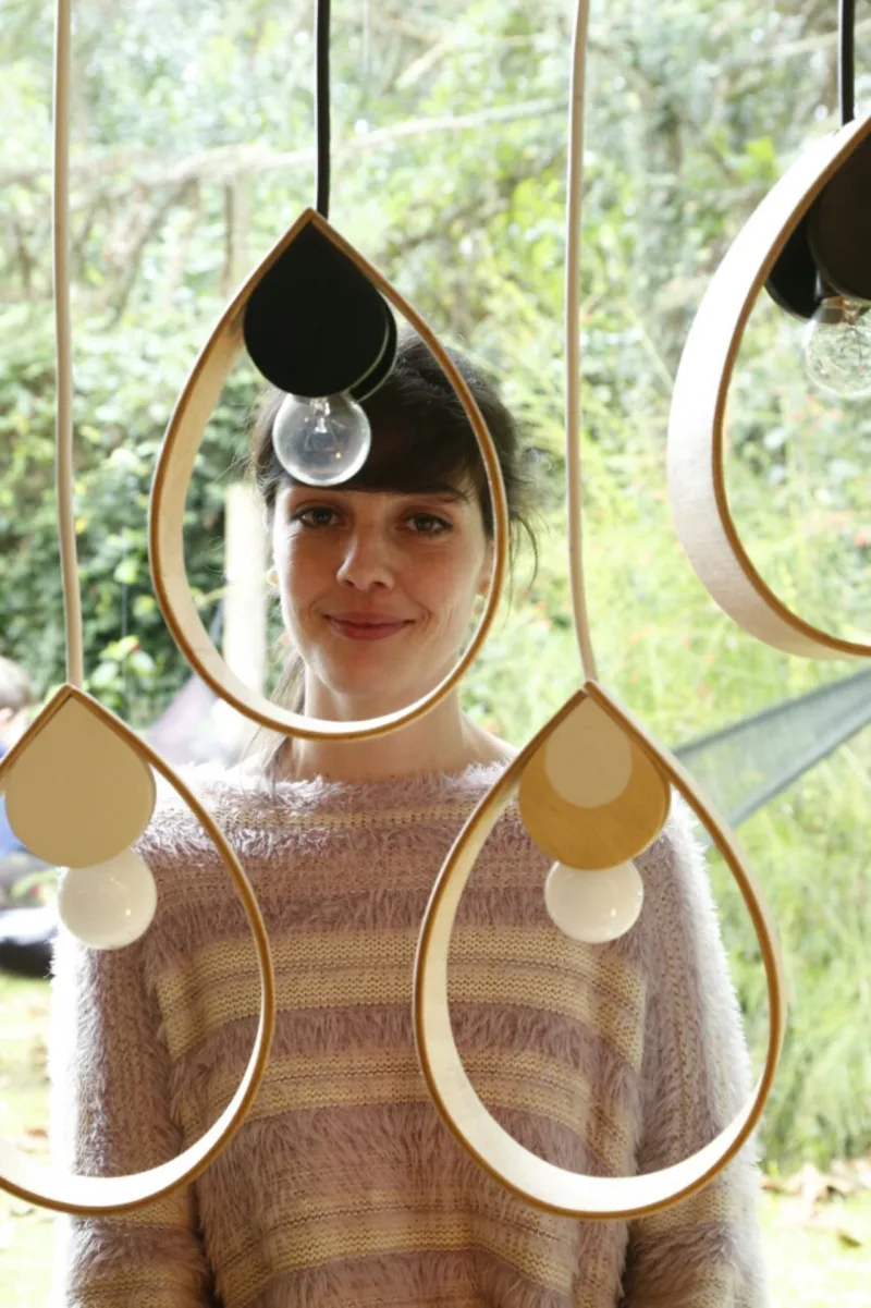 Essa é a Juliana Bello Schlichting, que toca a marca Guria Marcenaria Fina. No bazar ela apresenta a linha Orvalho. As luminárias são artesanais e para uso exclusivo com led. Custa R$ 130 a pendente e R$ 160 a de mesa.