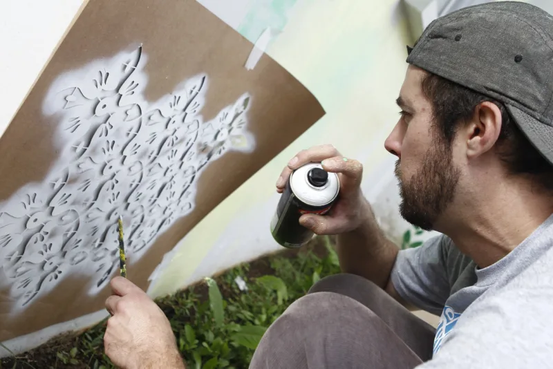 Olho Wodzynski aplicando técnicas de grafiti, num muro da casa. Foto: Antônio More/Gazeta do Povo.