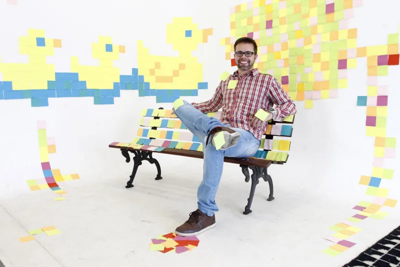 Ronaldo Cavalheri posa na sua intervenção de Post-its. Foto: Antônio More.