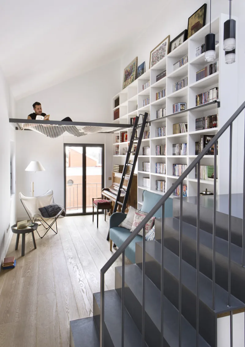 Em estilo moderno, o espaço para leitura do piso até quase o teto ganhou suporte para rede. Foto: Egue & Seta/ Divulgação