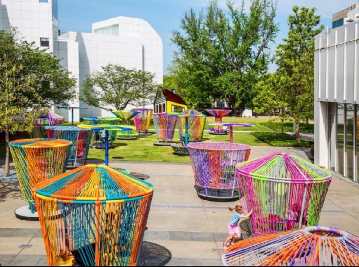 Crianças brincam com "piões" gigantes em Houston. Fotos: Divulgação Discovery Green Conservancy