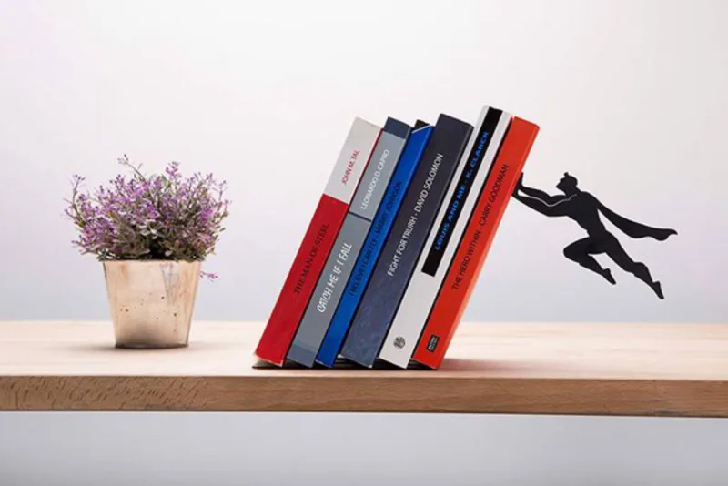 Superman segura os livros com toda sua força. / Fotos: Pinterest.
