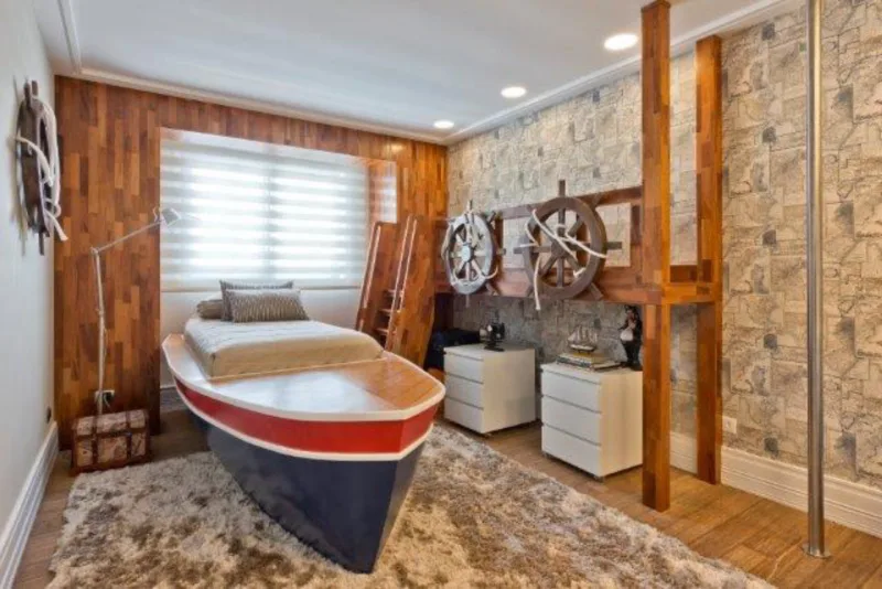 O quarto foi projetado para um menino de nove anos. O papel de parede tem tema de caça ao tesouro e a cama foi modelada em formato de barco.