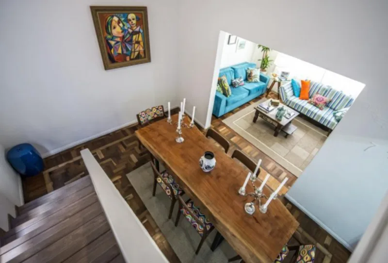 A reforma de uma casa antiga foi o caminho de Ricardo Sirigatti para encontrar um lugar só para ele. Na decoração: uma mesa estilizada, cadeiras de Aristeu Pires e muitas obras de arte. Foto: Letícia Akemi/Gazeta do Povo