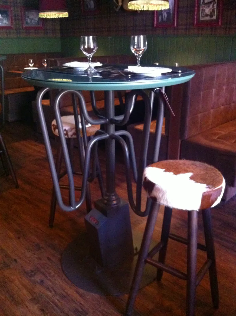 Mesa com pés de catraca, da Boulle, no Pub. De R$ 4.200 por R$ 2.940. / Crédito: Eloá Cruz.