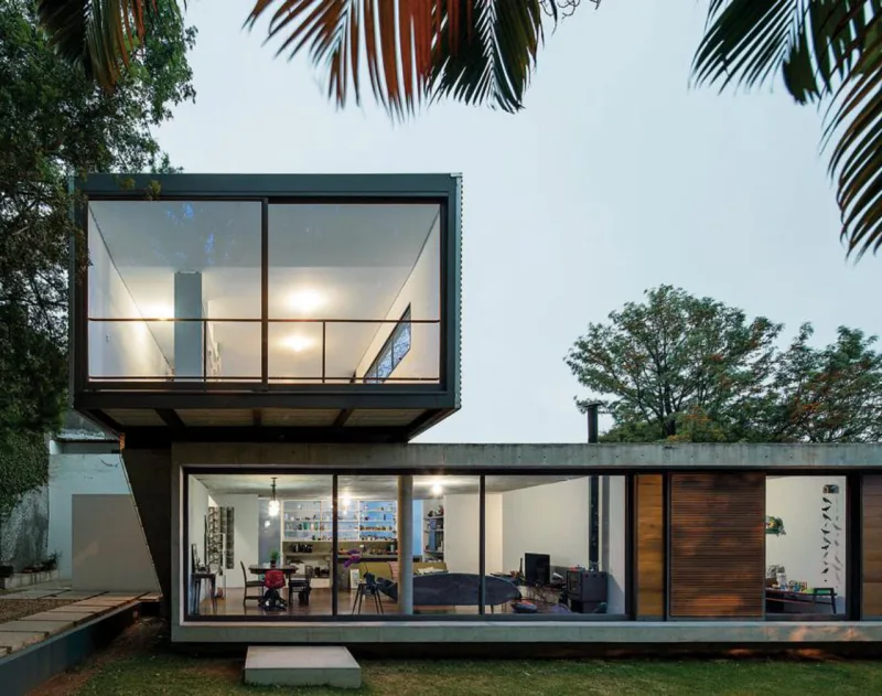 Concreto armado na parte inferior,  onde estão alocados todos os cômodos da residência, e estrutura metálica no bloco superior, que abriga  o escritório, foram os eleitos do Metro Arquitetos para um projeto residencial em São Paulo. Revelar os materiais e não compartimentar demasiadamente a casa, além de proporcionar a integração com o espaço externo, nortearam as decisões. Foto: Leonardo Finotti/Divulgação