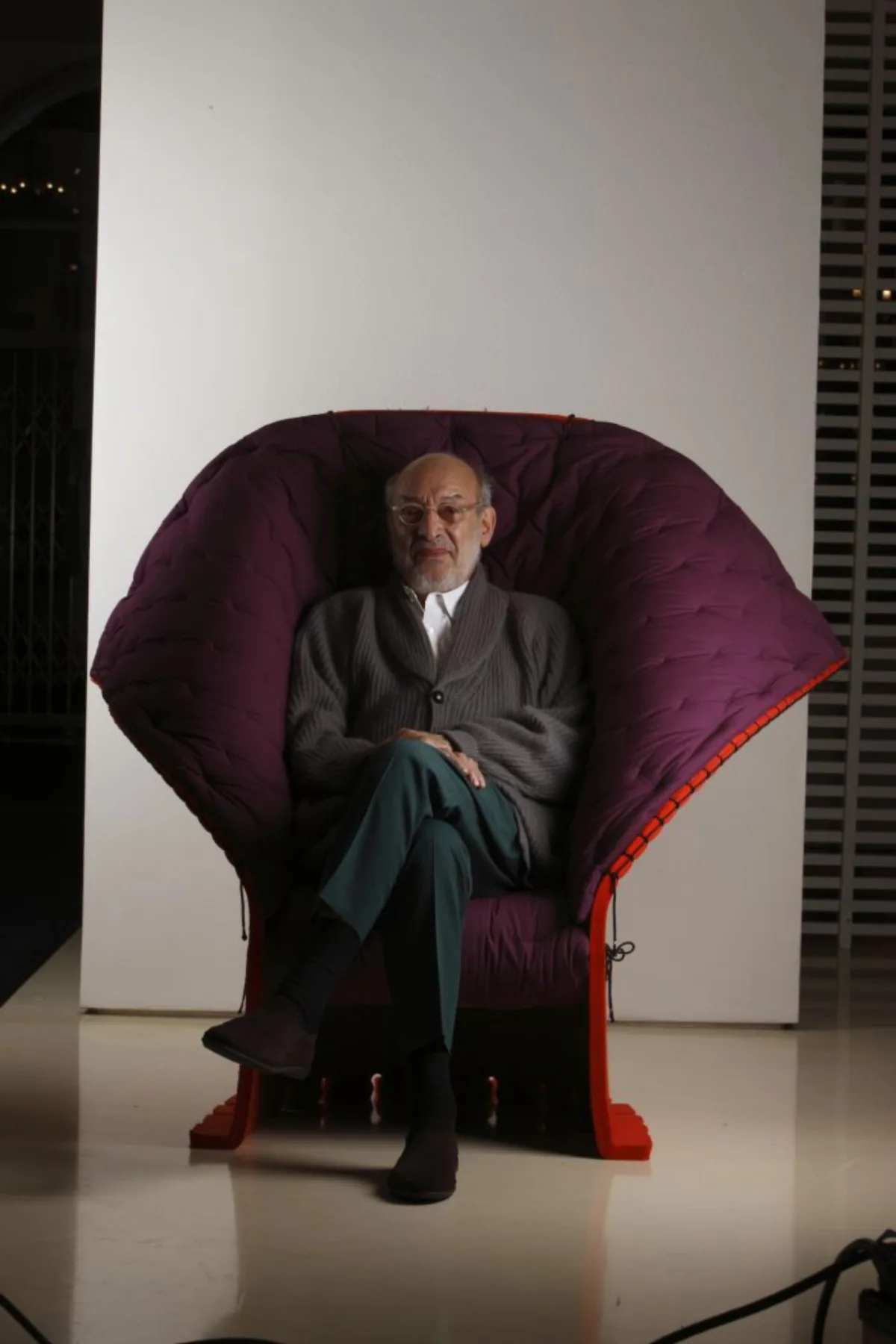 Bem acomodado, o arquiteto exibe sua poltrona Feltri