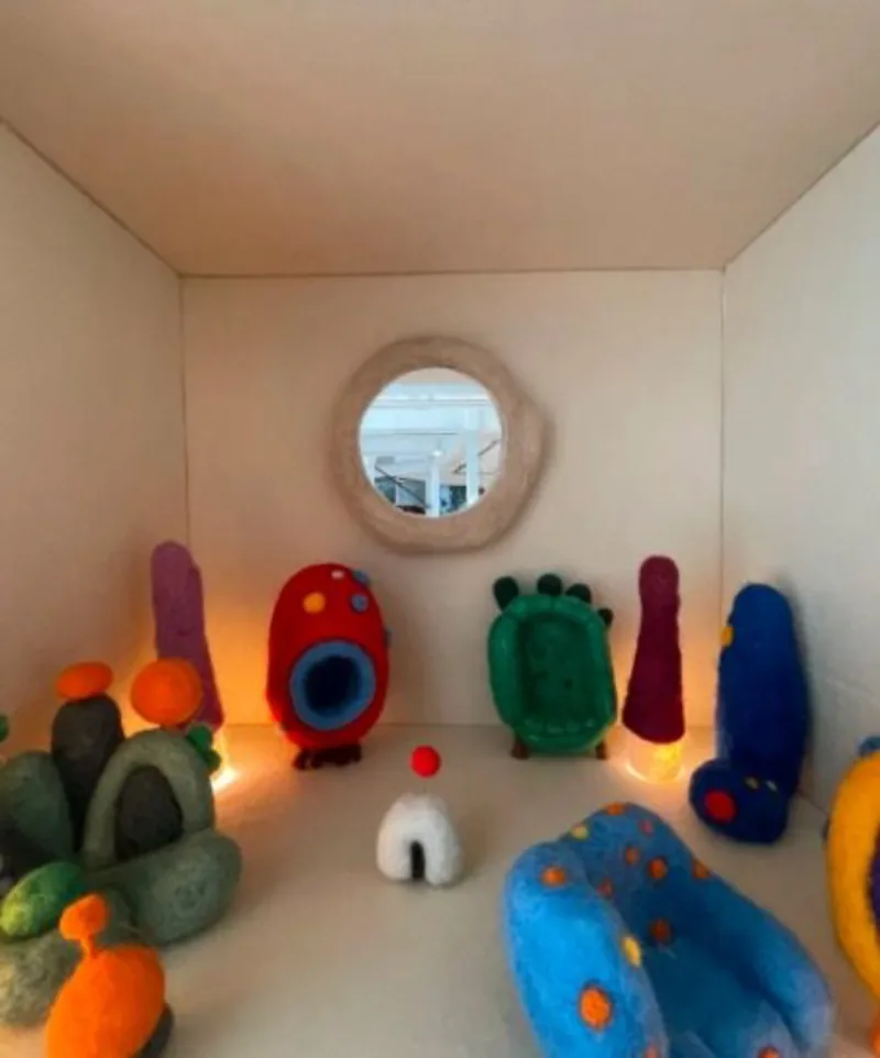Um minimundo gerado por IA. Foi o que os designers Nicole Tomazi e Sergio Cabral, do TomaziCabral, desenvolveram para a coleção “E aí, AI?”, apresentada na exposição "O que você quer ser quando crescer?", da Estar Móveis, durante a DW! 2023. A partir de testes com a tecnologia, produziram e expuseram uma linha de minimóveis e objetos em feltro, criando um cenário imagético.