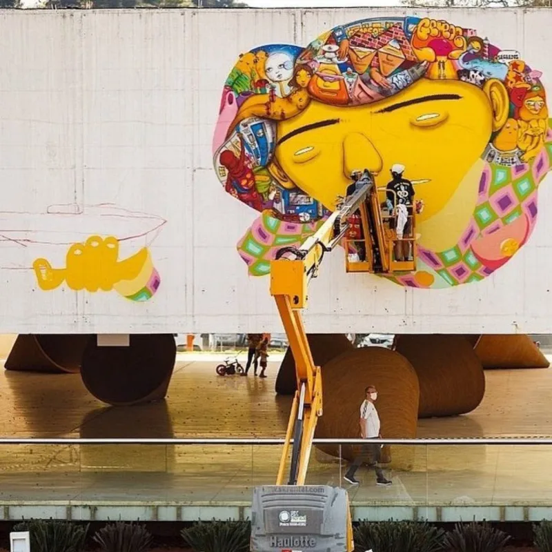 Registro de OSGÊMEOS grafitando a empena do MON.