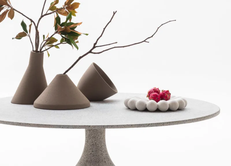 Mesa Balloon com acabamento em granilite. Parece um balão invertido, brincando com a base grande e pesada que vai afinando ao longo da altura.