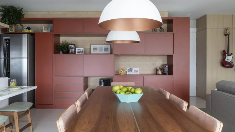 Armário desenhado pela arquiteta é a estrela da área social, que integra cozinha, sala de jantar, churrasqueira e sala de estar.