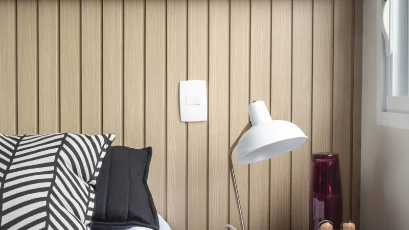 Painel de MDF atua como cabeceira e leva a sensação de aconchego ao ambiente.